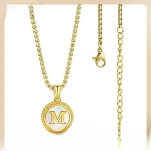 Macro detail of gold 18K plated stainless steel necklace with shell inlay letter M pendant