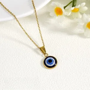 Detailed close-up of 18K gold plated evil eye pendant on stainless steel chain