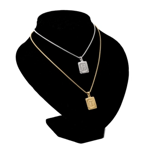 Close-up of rectangular gold and silver letter pendants on durable box chains