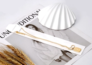 Detail of 18K gold plated stainless steel letter T pendant necklace on fashion magazine