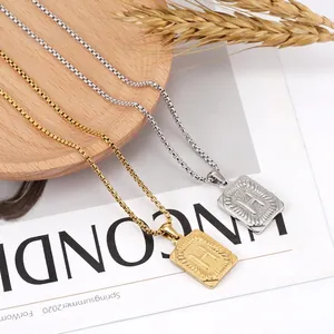 Gold and silver square letter pendant necklaces with box chain on a minimalist tray