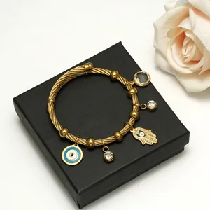 Gold-plated stainless steel twisted cable bracelet with Hamsa and Evil Eye charms