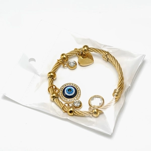 Detailed shot of golden braided evil eye bracelet with heart charm and crystal accents