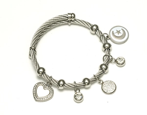 Vue détaillée d'un bracelet en fil d'argent avec breloques cœur, lune et cristal