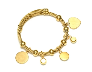 Détail du bracelet câble torsadé en acier doré avec breloque cœur et billes polies