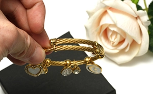 Détail du bracelet en fil doré avec breloques cœur et étoile-lune sur boîte cadeau
