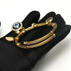 Gold cable twist evil eye bracelet for women with blue eye charm and heart pendant