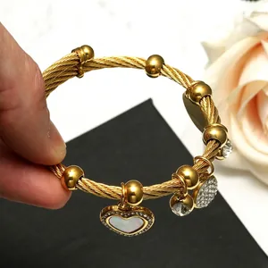 Bracelet doré en fil d'acier tressé avec pendentif cœur en nacre et strass brillants
