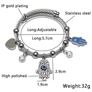 Macro view of stainless steel wire bracelet with Hamsa Hand and Evil Eye charms