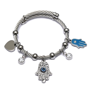 Detailed view of silver stainless steel cable bracelet with Hamsa Hand and heart charms