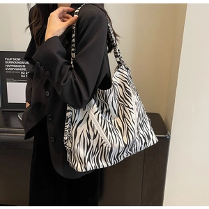 Detailed view of the zebra pattern canvas bag with dual white diagonal zippers