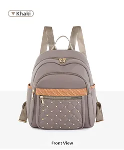 Front view of khaki oxford backpack featuring orange stripes and quilted rivet detail