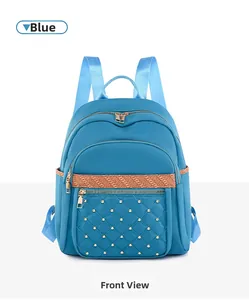 Close-up of blue Oxford fabric backpack featuring quilted pocket and golden rivet details