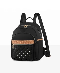 Detail of black quilted oxford backpack with gold rivets and orange woven strap trim