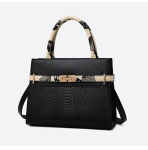 Close-up of black leather handbag with snakeskin texture straps and gold twist lock
