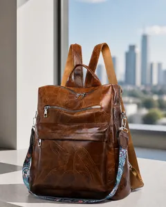 Close-up of vintage brown leather backpack with leaf pattern stitching and ethnic strap