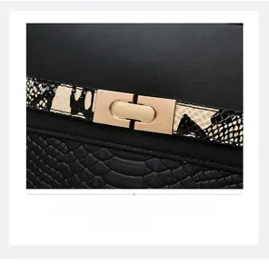 Detail of a black leather handbag featuring a golden metal twist lock and snakeskin texture
