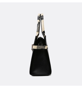 Side view of black tote bag featuring stylish snake pattern trim and metal ring hardware