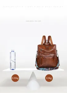 Lightweight brown vintage leather backpack showing 0.5kg net weight on a creative balance scale