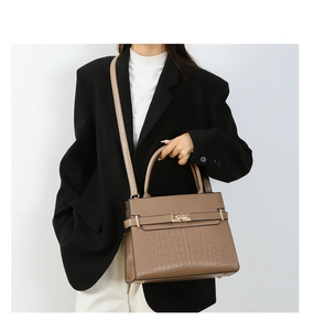 Chic khaki tote bag with crocodile embossing, gold lock detail, styled with a black blazer