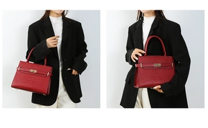 Detail showing red crocodile embossed leather texture and golden metal twist lock on bag