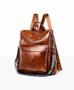 Detail view of vintage brown backpack with leaf-shaped stitching and ethnic strap