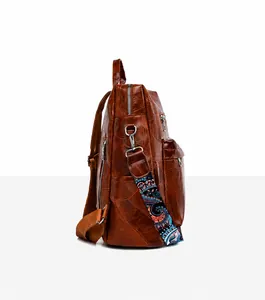 Side view of brown retro backpack with colorful woven strap and silver zipper pocket