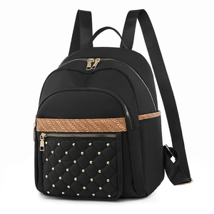 Women's black nylon backpack with gold quilted pocket and brown textured ribbon detail