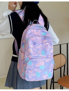 Detail view of purple nylon backpack with starry sky pattern and multi-pocket structure