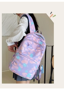 Detail of dreamlike purple backpack with constellation patterns and cute cartoon charm
