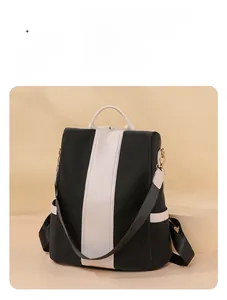 Detail of minimalist black and white contrast nylon backpack with leather accents and gold hardware