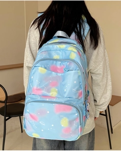 Detail of light blue nylon backpack with nebula patterns and multi-layer zippers