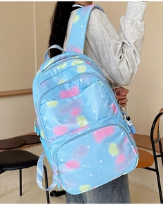 Detail of blue galaxy nylon backpack with astronaut charm and 'Beautiful' embroidery