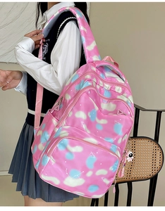Pink student backpack with blue cloud patterns and astronaut keychain accessory
