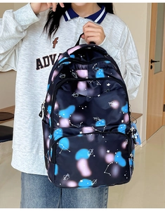 Detail of water-resistant nylon backpack with vibrant blue and pink galaxy nebula pattern