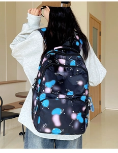 Detail showing the ergonomic wide straps and side pocket of the nylon star printed backpack