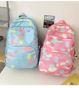 Detail of blue and pink tie-dye nylon backpacks with starry constellations and charms