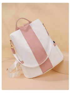 Detail of a white and pink color-block backpack with gold metal hardware on display