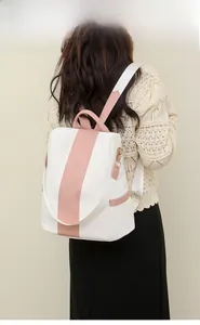 Rear view of a stylish two-tone white leather backpack with pink stripe on model