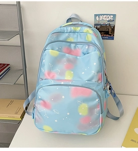 Close-up of light blue nylon backpack with pastel cloud pattern and heart embroidery