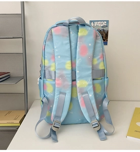Detail of light blue nylon backpack with star pattern and colorful circular tie-dye accents