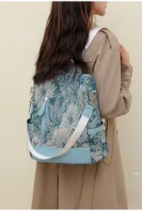 Detail of blue floral jacquard nylon backpack with silver hardware and anti-theft design