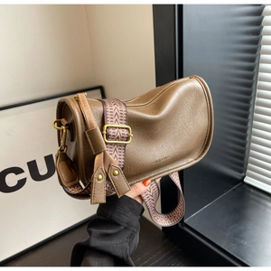 Detail of brown cylinder saddle bag with litchi texture and ethnic pattern strap