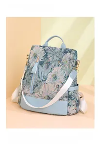 Detail of light blue floral jacquard backpack with white fabric strap and gold hardware