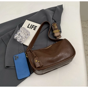 Brown vintage saddle bag detail showing matte leather texture and two strap options