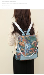 Detail of floral tapestry backpack showing side pocket and light blue leather trim
