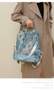 Detail of vintage floral jacquard backpack with light blue leather trim and canvas strap