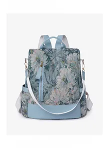 Close-up of blue floral nylon backpack with light blue leather trim and fabric strap
