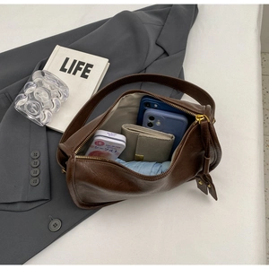 Macro shot showing large capacity interior of brown leather saddle bag with accessories