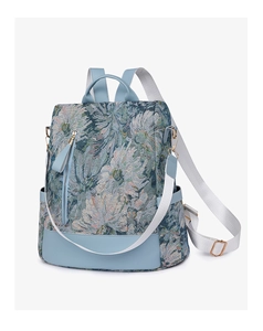 Detail of floral nylon backpack featuring light blue pattern and faux leather bottom